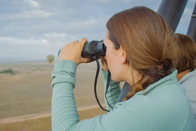Safari guest using binoculars during a Serengeti balloon flight.